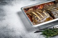 Plaice or Flounder flat fish baked in a tomato sauce in baking tray. White background. Top view. Copy space