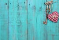 Plaid heart and bronze skeleton key hanging on antique teal blue wood door Royalty Free Stock Photo