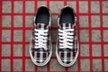 plaid patterned sneakers standing on a concrete surface