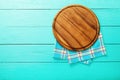 Plaid tablecloth and brown cutting board for pizza on blue wooden background. Top view and copy space. Mock up Royalty Free Stock Photo