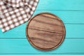 Plaid tablecloth and brown cutting board for pizza on blue wooden table. Wood background. Top view and mock up. Copy space Royalty Free Stock Photo