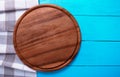Plaid tablecloth, brown food cutting board for pizza on blue wooden table. Wood background. Top view and mock up.Copy space Royalty Free Stock Photo