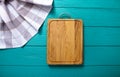 Plaid tablecloth, brown cutting board for pizza on blue wooden table. Wood background. Top view and mock up.Copy space Royalty Free Stock Photo