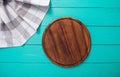 Plaid tablecloth, brown cutting board for pizza on blue wooden table. Wood background. Top view and mock up.Copy space Royalty Free Stock Photo