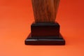 A plain award plaque made of wood on an orange background and used as a keepsake. Suitable for Awards, trophies, certificates, web