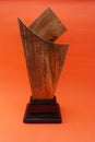 A plain award plaque made of wood on an orange background and used as a keepsake. Suitable for Awards, trophies, certificates, web