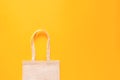 Plain canvas shopping bag on yellow background. Zero waste and plastic free concept