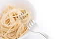 Plain cooked spaghetti pasta in white bowl and on fork, on white background.