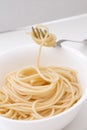 Plain cooked spaghetti pasta in white bowl and on fork, on white background. Royalty Free Stock Photo