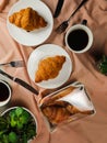 Plain Croissant served on wooden board with cup of black coffee isolated on napkin with knife and fork top view of french Royalty Free Stock Photo