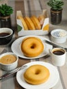 Plain Donuts with dip and cup of coffee isolated on napkin side view of baked food breakfast on table