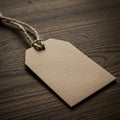A plain, rectangular beige paper tag lies on a textured wooden Royalty Free Stock Photo