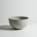 A plain, round ceramic bowl with a smooth matte finish and light gray color. It rests o Royalty Free Stock Photo