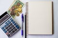 Plain Spiral Notebook With Pen Beside Calculator And Coins On Table. Simple Notepad And Ballpen Alongside Calculation Royalty Free Stock Photo