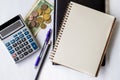Plain Spiral Notebook With Pen Beside Calculator And Coins On Table. Simple Notepad And Ballpen Alongside Calculation Royalty Free Stock Photo