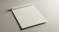 A plain, unlined notepad with a white sheet is placed on a light beige surface. The pad is slightly Royalty Free Stock Photo