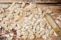 Plain view of finished raw fresh gnocchi on wooden background with manual gnocchi maker Royalty Free Stock Photo