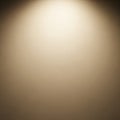 A plain wall with an illuminated spot at the top creates a gentle gradient of light. The Royalty Free Stock Photo