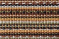 Plain weave fabric macro texture. Cloth background with horizontal strips of white, yellow, green, brown and black colors. Textile Royalty Free Stock Photo