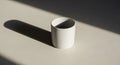 A plain white ceramic cup sits on a light-colored surface, casting a distinct shadow to the left. Royalty Free Stock Photo