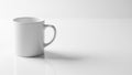 A plain white ceramic mug with a curved handle sits on a glossy white surface Royalty Free Stock Photo