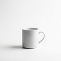 A plain white ceramic mug with a curved handle sits on a smooth, white surface. The Royalty Free Stock Photo