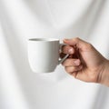 A plain white ceramic mug by the handle, set against a soft white Royalty Free Stock Photo