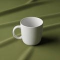 A plain white ceramic mug with a large handle rests on an olive green Royalty Free Stock Photo