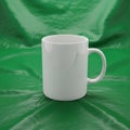 A plain white ceramic mug is placed against a draped green fabric Royalty Free Stock Photo