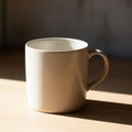 A plain white ceramic mug with a rounded handle is placed on a wooden surface. Royalty Free Stock Photo
