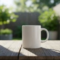 A plain white ceramic mug sits on a wooden table outdoors. The table\'s surface has a Royalty Free Stock Photo