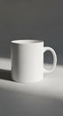 Plain white ceramic mug with a smooth surface and a rounded handle. It rests on a Royalty Free Stock Photo