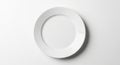 A plain white ceramic plate is centered on a white background. The plate is round wit Royalty Free Stock Photo