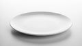 White ceramic plate with a glossy finish sits against a smooth light Royalty Free Stock Photo