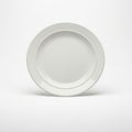 A plain white ceramic plate is positioned upright against a neutral background Royalty Free Stock Photo