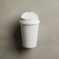 A plain white disposable coffee cup with a plastic lid, placed against a textured grey Royalty Free Stock Photo