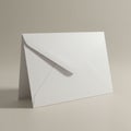 A plain white envelope with a triangular flap is placed upright against a neutral beige Royalty Free Stock Photo