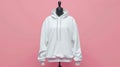 Plain white hoodie on a mannequin against a pink background