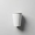 A plain white paper cup centered against a light gray background. The cup casts a soft shadow to Royalty Free Stock Photo