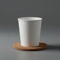 A plain white paper cup is positioned on a circular cork coaster. The cup has a smooth Royalty Free Stock Photo