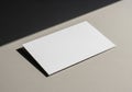 A plain white rectangular business card rests on a textured, light Royalty Free Stock Photo