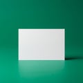 A plain white rectangular card positioned upright against a solid green background. Royalty Free Stock Photo