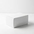 A plain white rectangular cardboard box, closed and resting on a white Royalty Free Stock Photo