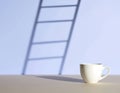 Plain white teacup on surface casting shadow of tall ladder on light blue background evoking creativity and hope Royalty Free Stock Photo