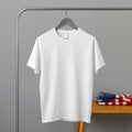 A plain white tee shirt hanging on a hanger with a folded flag in the background on a wood table Royalty Free Stock Photo