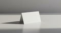 A plain white tent card placed on a smooth, light-colored surface, casting a shadow. The Royalty Free Stock Photo