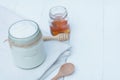 Plain yoghurt in white bowl, honey, cereal, raisin and wood spoon on white wooden table background Royalty Free Stock Photo