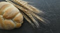Plaited white bread with wheat heads on black background Royalty Free Stock Photo