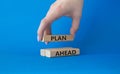 Plan ahead symbol. Wooden blocks with words Plan ahead. Beautiful blue background. Businessman hand. Business and Plan ahead Royalty Free Stock Photo