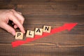 PLAN concept. Red arrow indicates the development and growth. Steps, wooden background Royalty Free Stock Photo